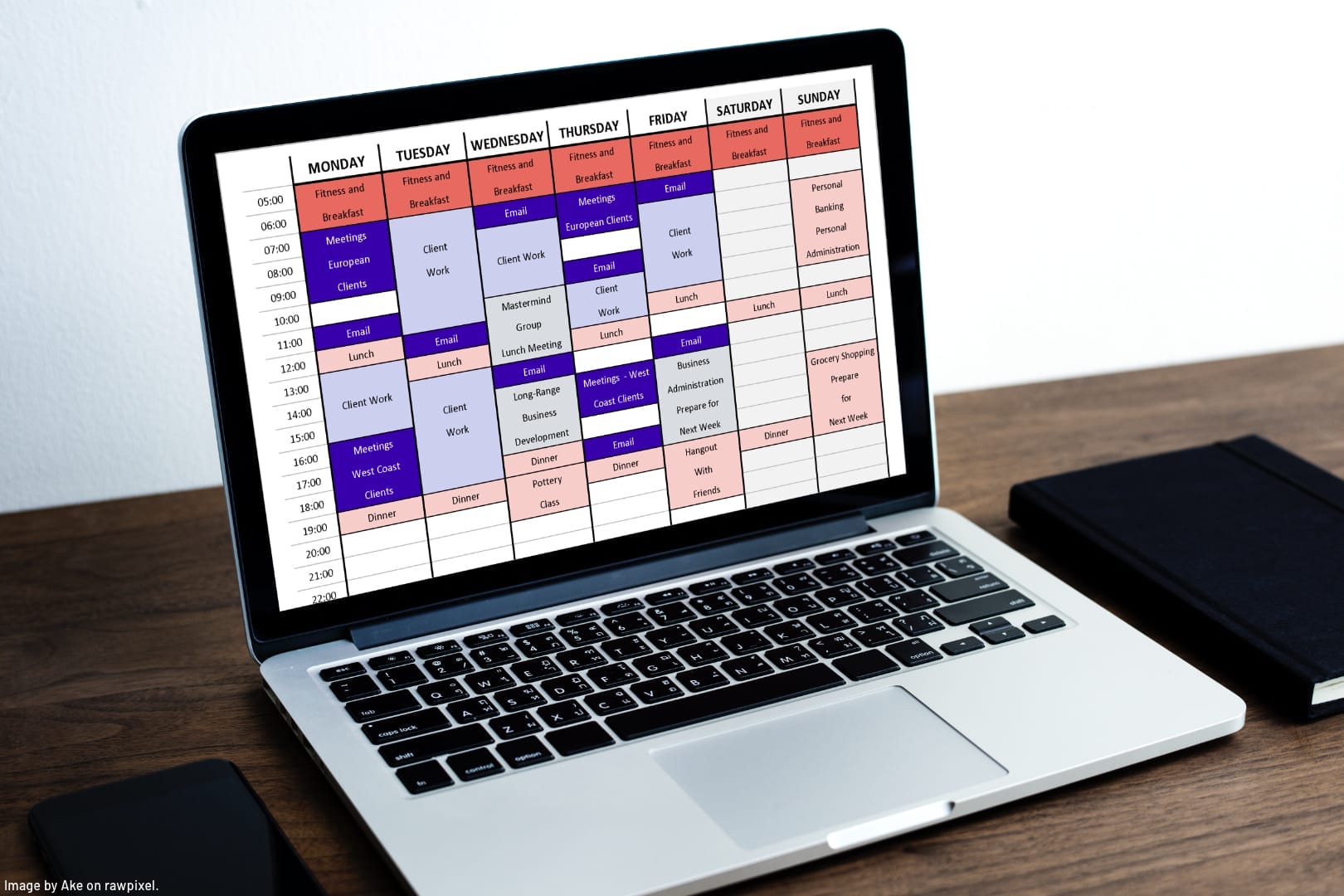 laptop on a desk with a weekly calendar displayed on the screen