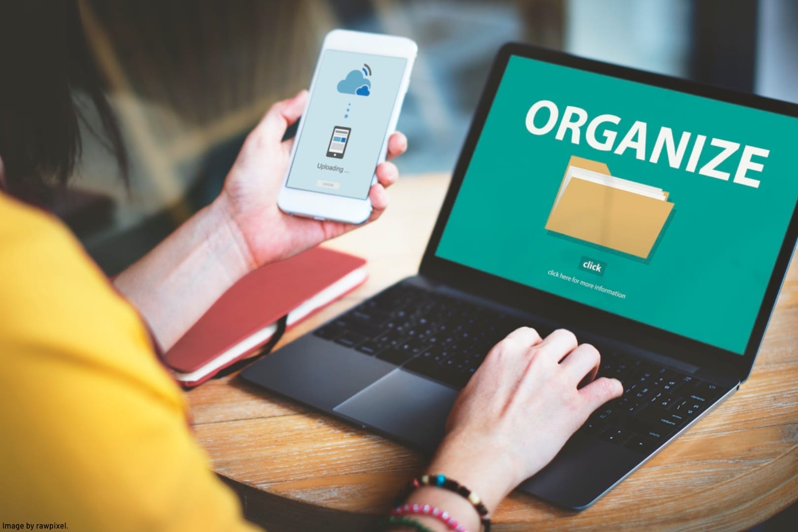a person working on a laptop and mobile phone organizing files and adopting better file naming conventions