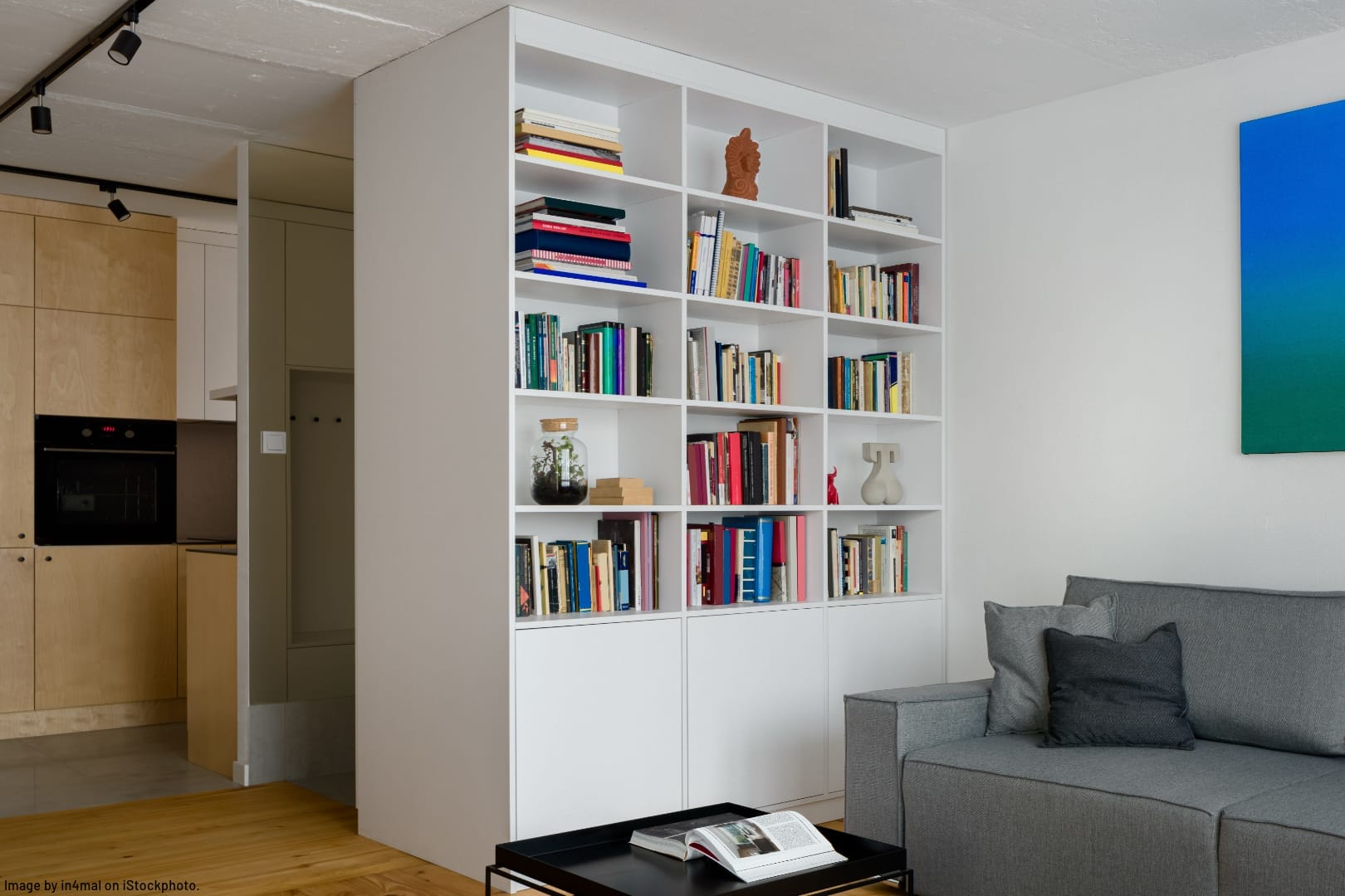 white bookshelf in modern apartment stylized to look less messy