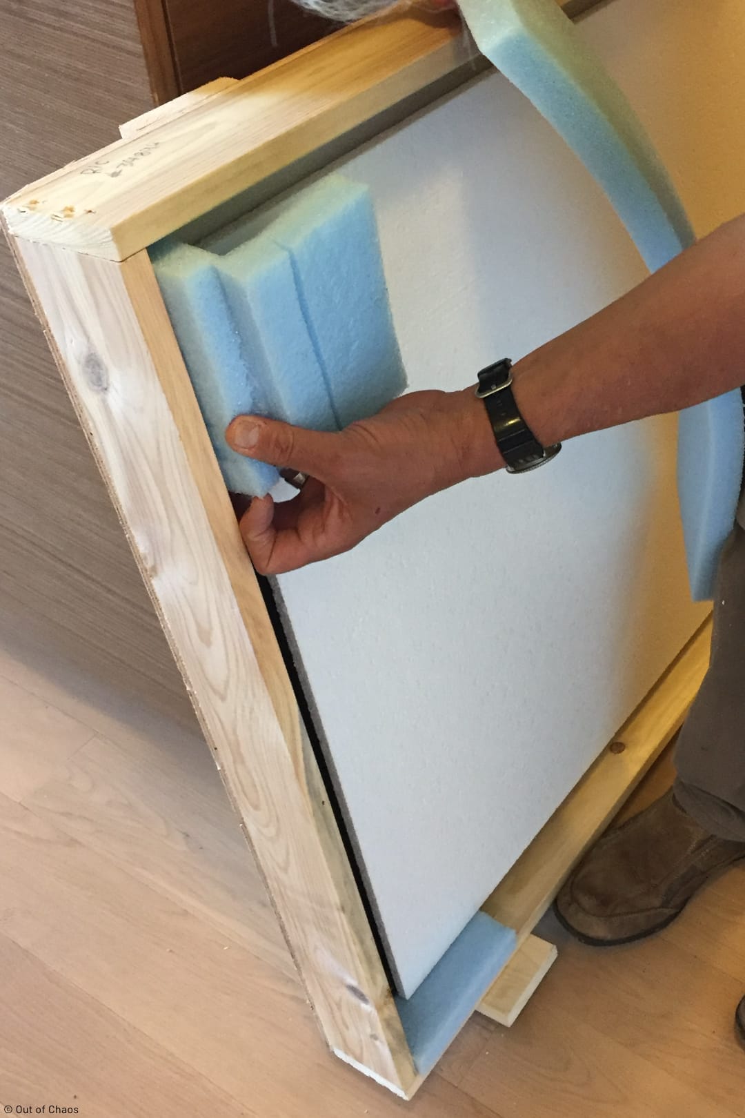 person building custom crate to protect large wall hanging from damage during household move