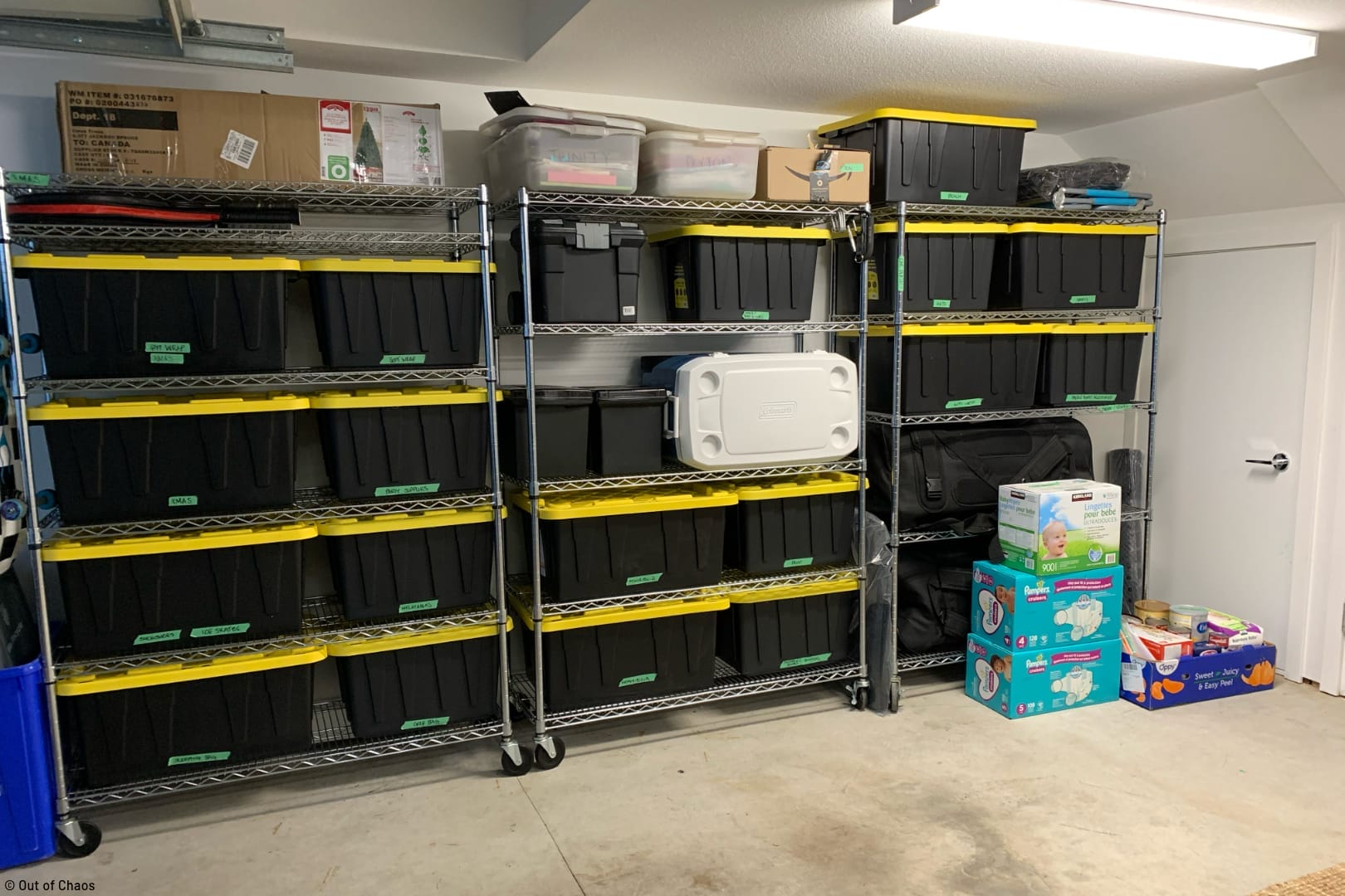 black bins with yellow lids neatly arranged on stainless steel shelving highlighting the ultimate guide to organizing your garage
