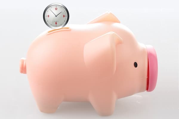 Clock Falling Into Piggy Bank