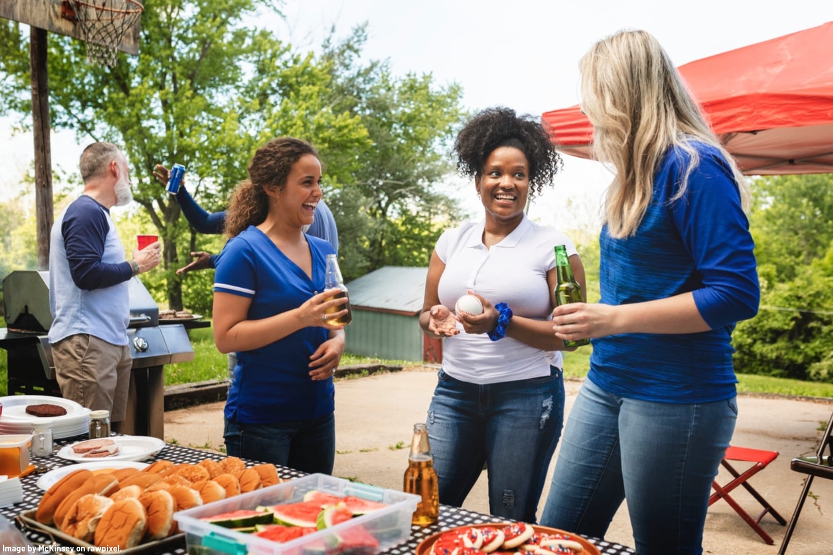 people standing at a barbeque buffet table on a patio in the summer weather