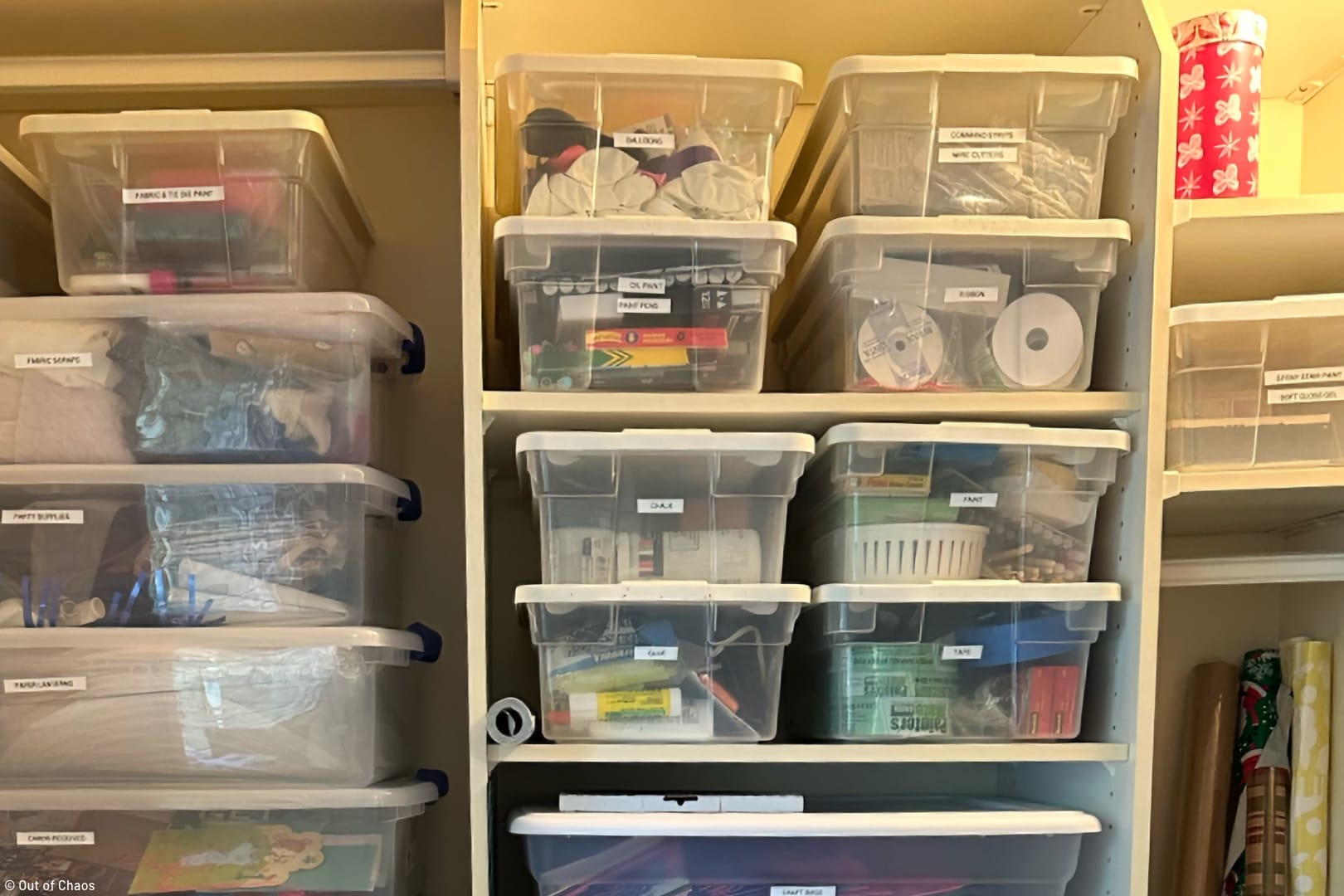 labelled plastic shoe boxes filled with household items stacked neatly on closet shelves