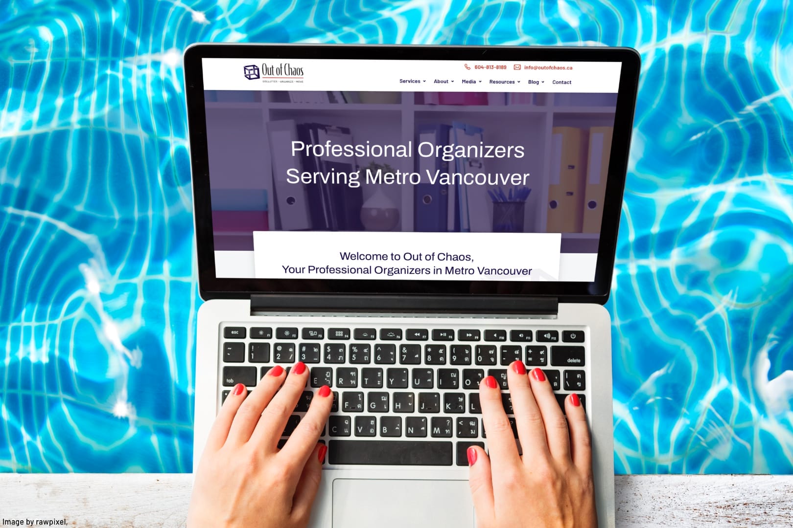 person working on a laptop sitting at a swimming pool
