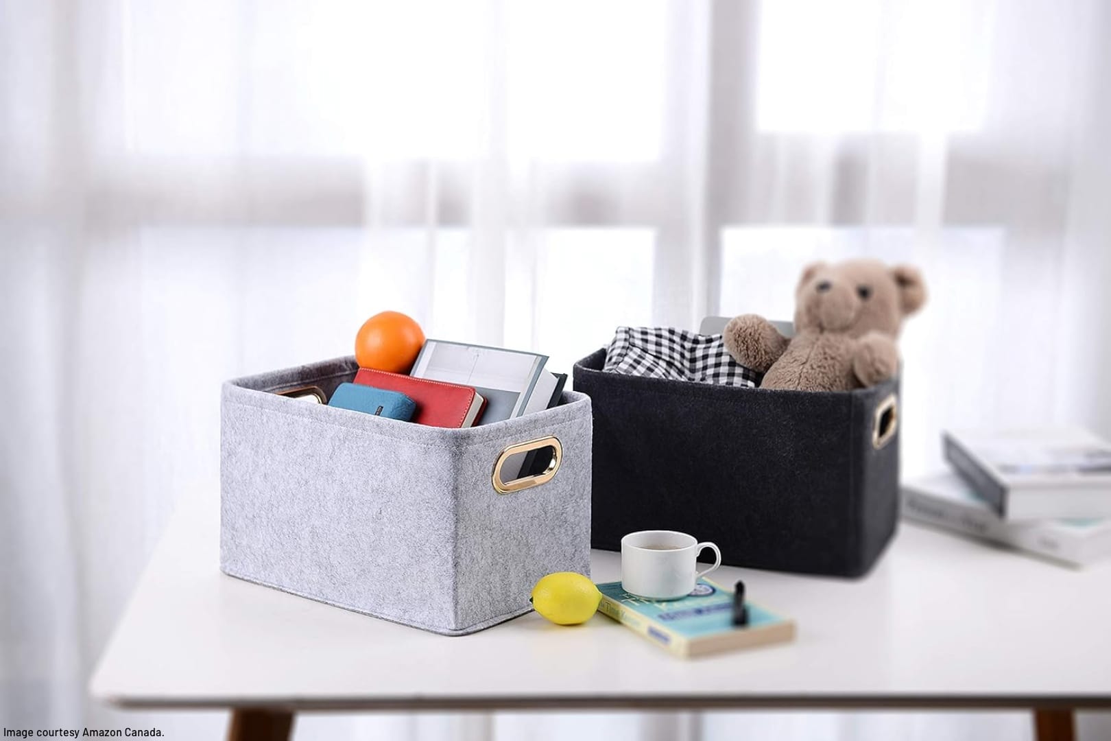 two felt bins on a table filled with various household goods